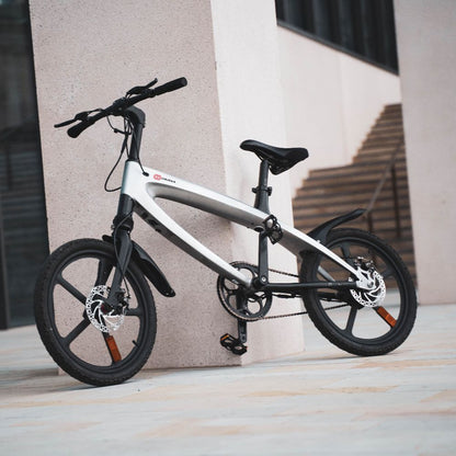 Cruzaa City e-bike gunmetal grey leaning against a wall with a building in the background