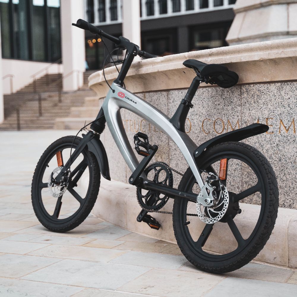 Cruzaa City e-bike gunmetal grey with a building in the background