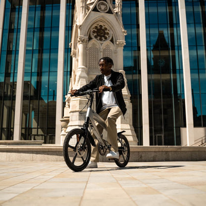 Cruzaa City e-bike lifestyle image of a Person in front of a large architectural building with glass windows