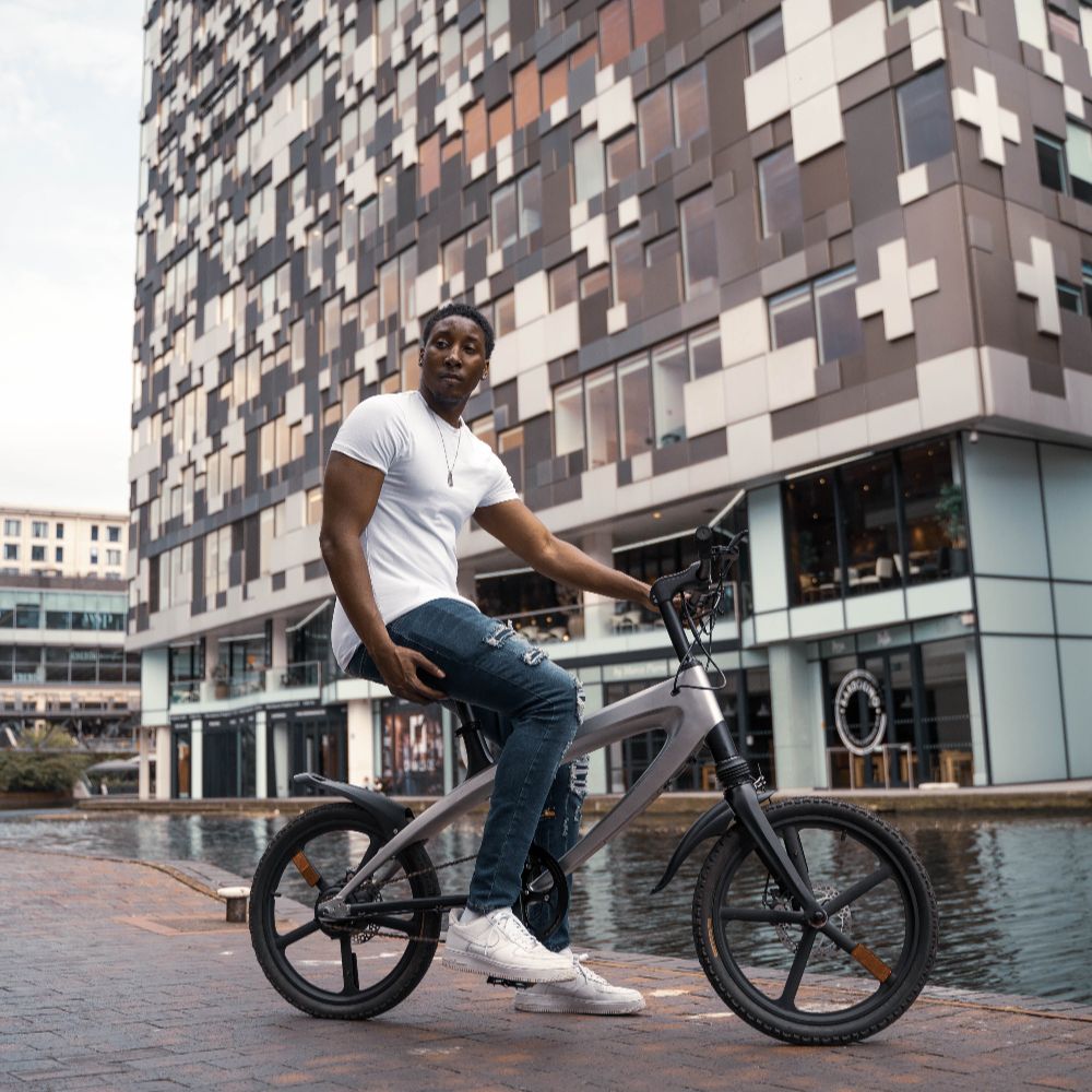 Cruzaa City e-bike lifestyle image of a Person riding in front of a modern building