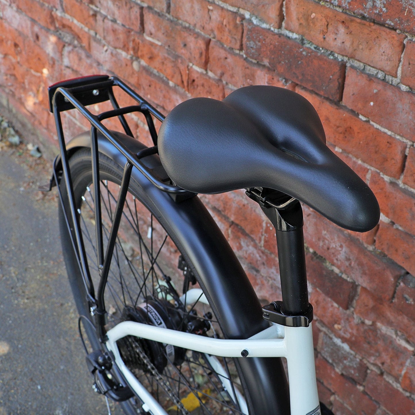 Falcon Liberty Hybrid saddle Selle Mio and rack against a brick wall