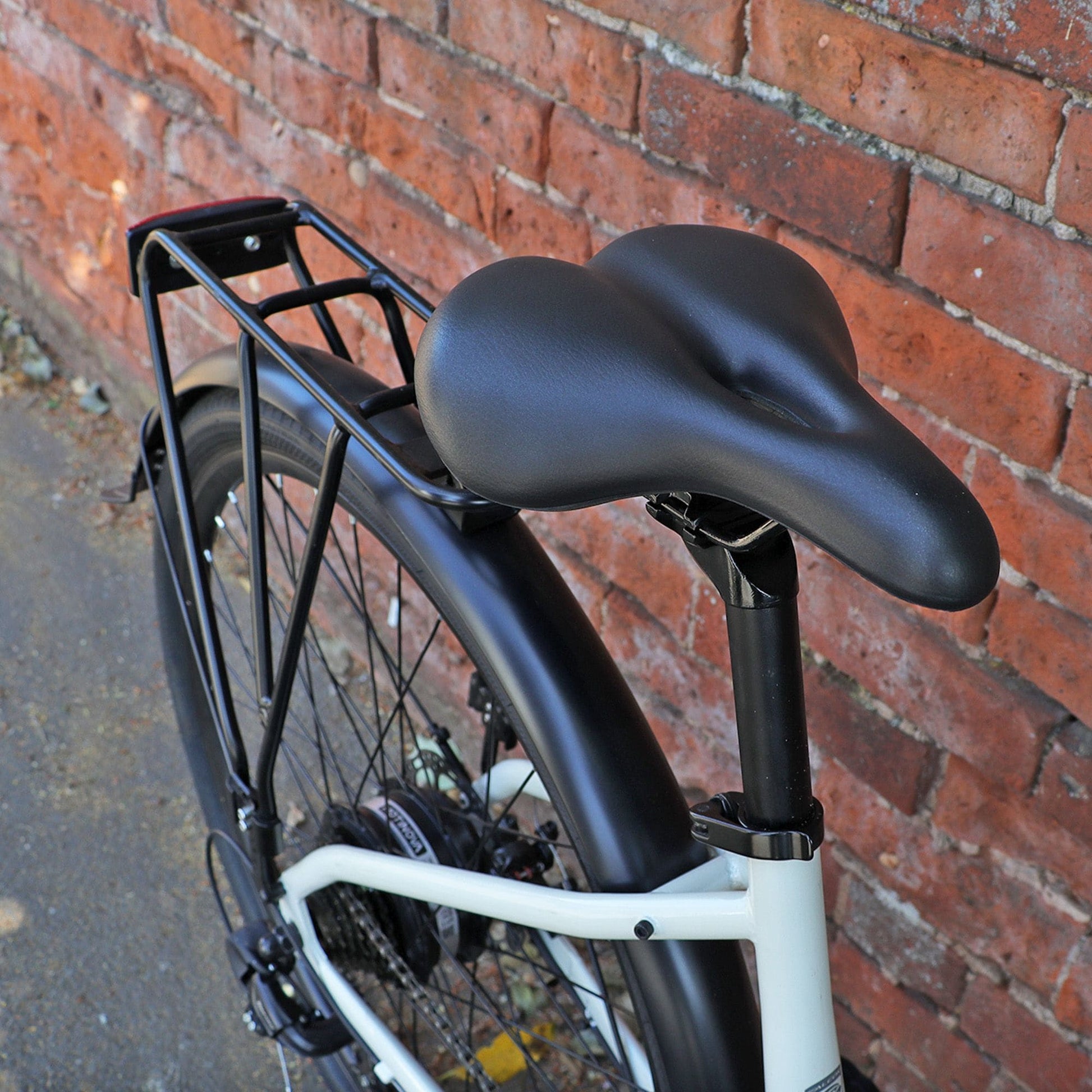 Falcon Liberty Hybrid saddle Selle Mio and rack against a brick wall