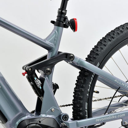 Revom M1 eMTB suspension Close-up with visible branding on a light grey background