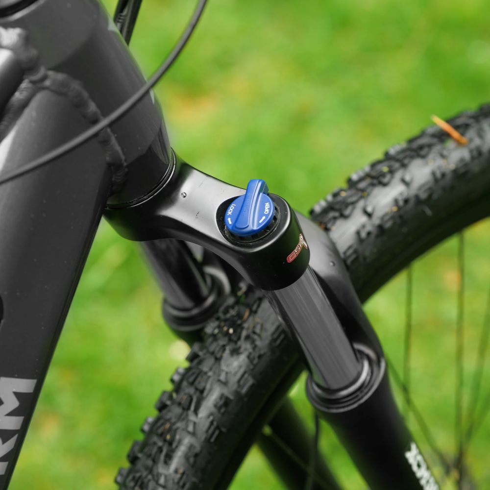 Roxform Gravion crossroad eMTB suspension lock Close-up against a blurred green background.