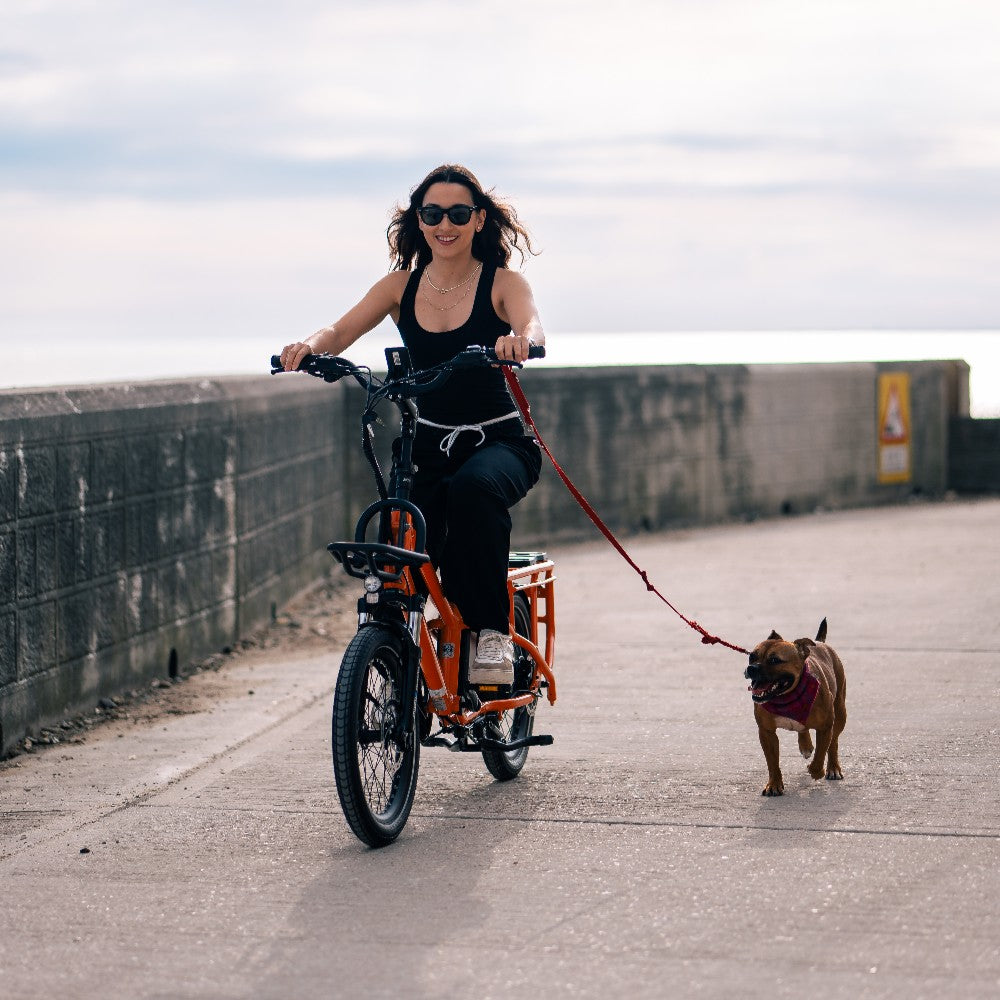 Roxform Porto S Lifesyle image of a Woman riding with a dog on a leash in a beach setting