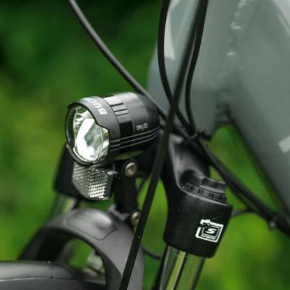 Roxform Stride L e-bike front light with a blurred green background