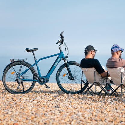 Roxform Valor L e-bike Two people sitting on chairs on a pebbly beach.