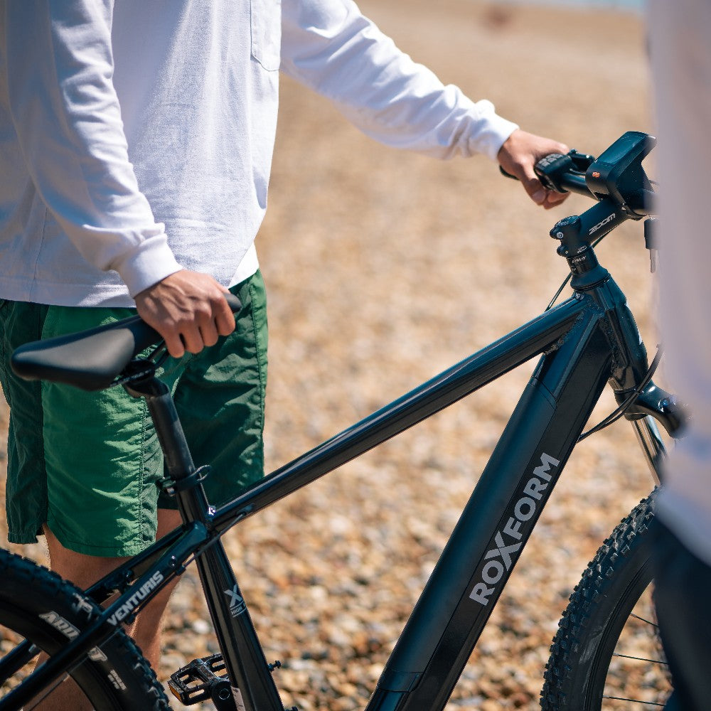 Roxform Venturis eMTB lifestyle image Person holding the bicycle on a blurred natural background