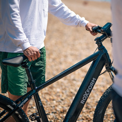 Roxform Venturis eMTB lifestyle image Person holding the bicycle on a blurred natural background