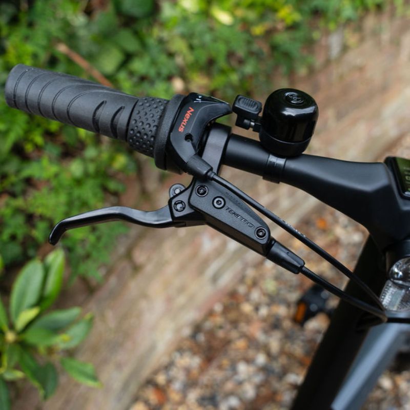 e-go CarbonLite3S handlebar close-up with brake lever and throttle, blurred natural background